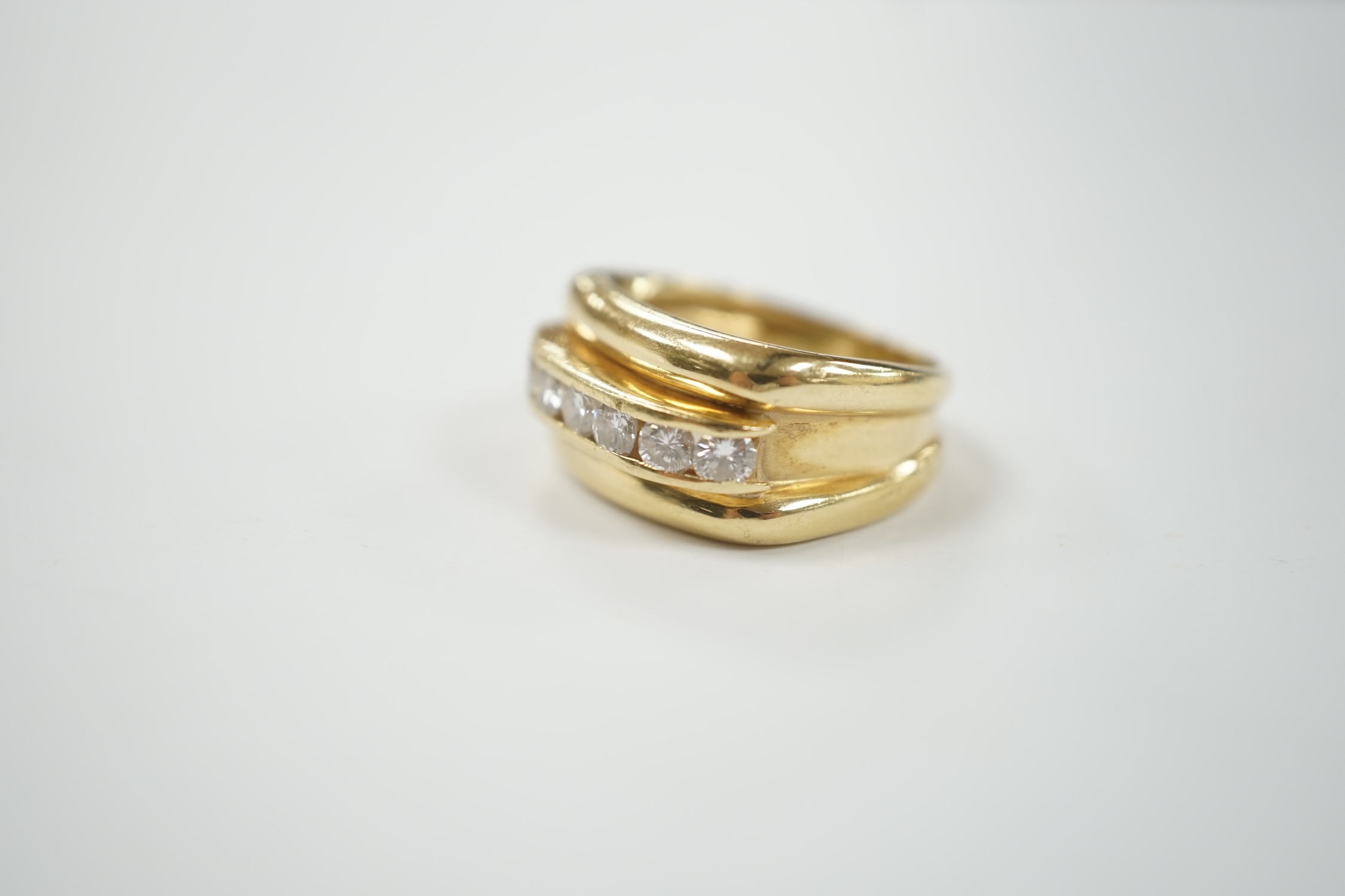 A yellow metal and channel set seven stone diamond set half hoop ring, size M/N